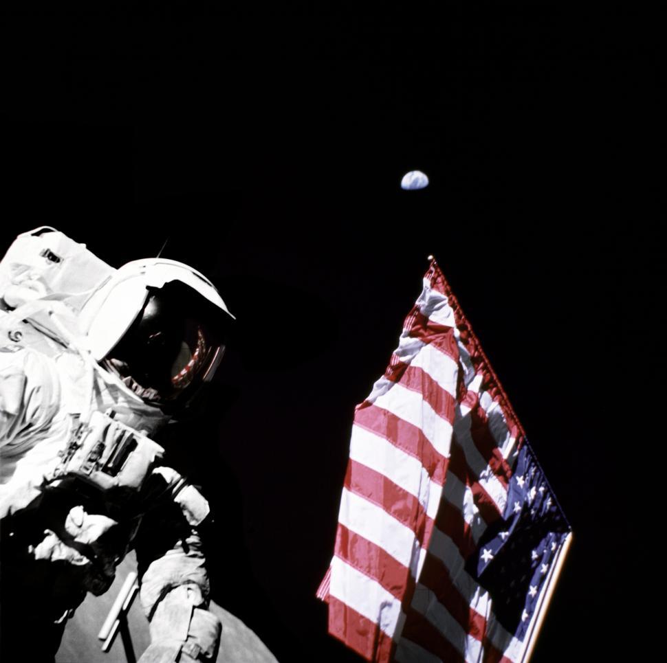 Free Image of A Man in a Spacesuit Standing Next to an American Flag 
