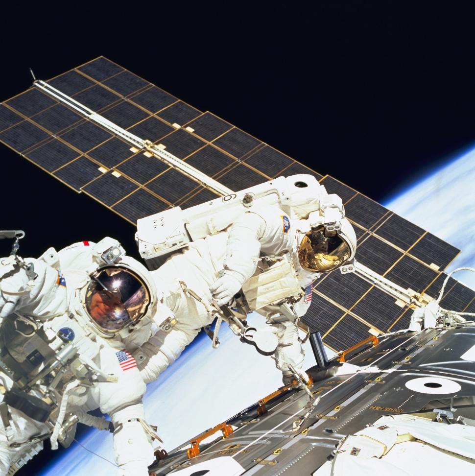 Free Image of Astronaut in Outer Space Next to a Satellite 