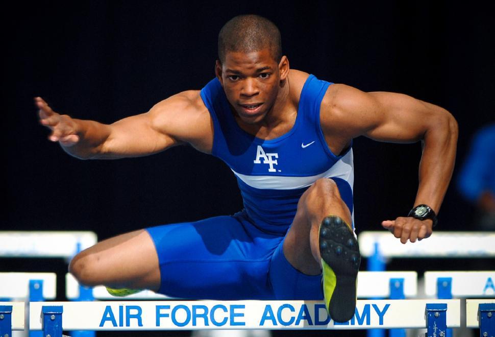 Free Image of Man in Blue Uniform Jumping Over Hurdle 