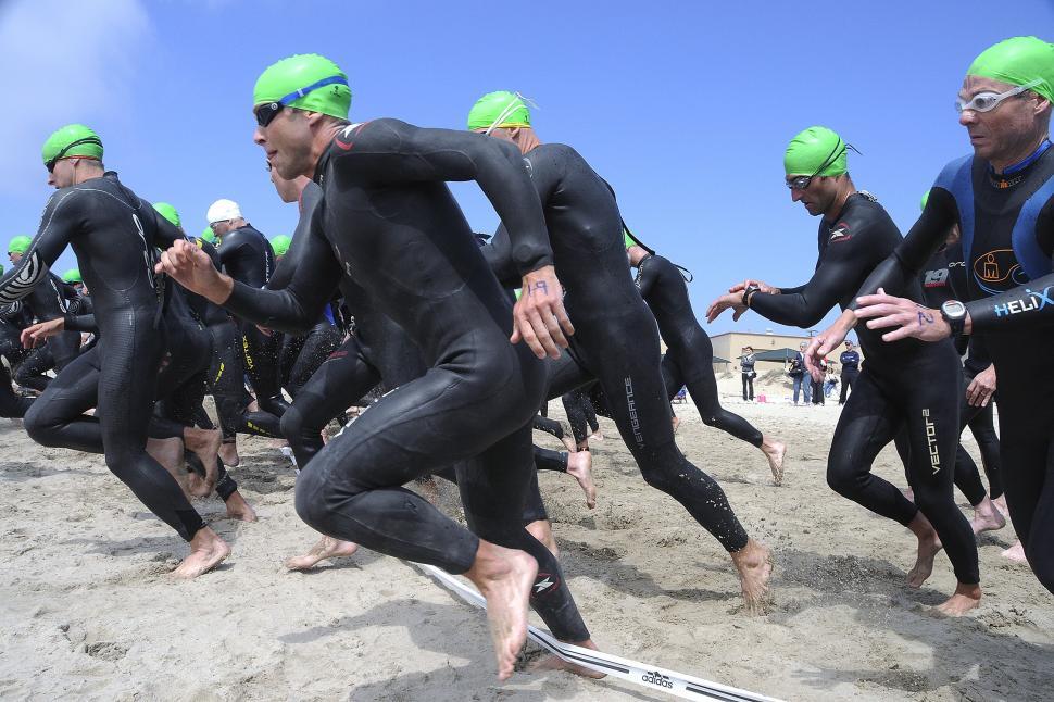 Free Image of Group of Men in Wetsuits and Swimming Caps on a Beach 