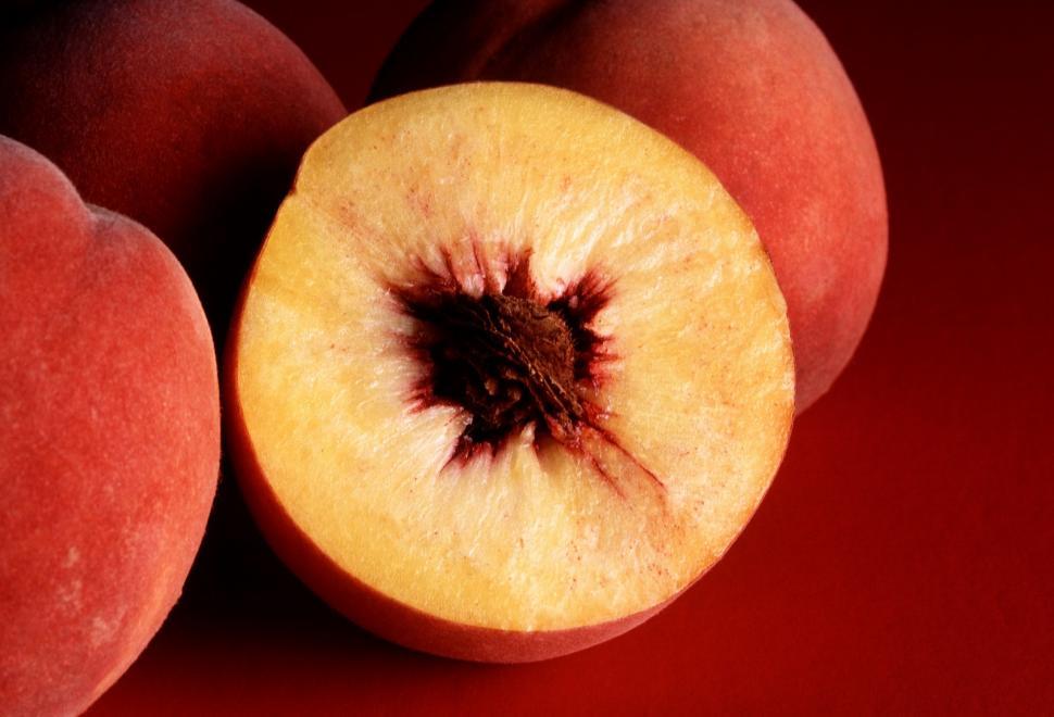 Free Image of Close Up of Sliced Peach on Red Background 