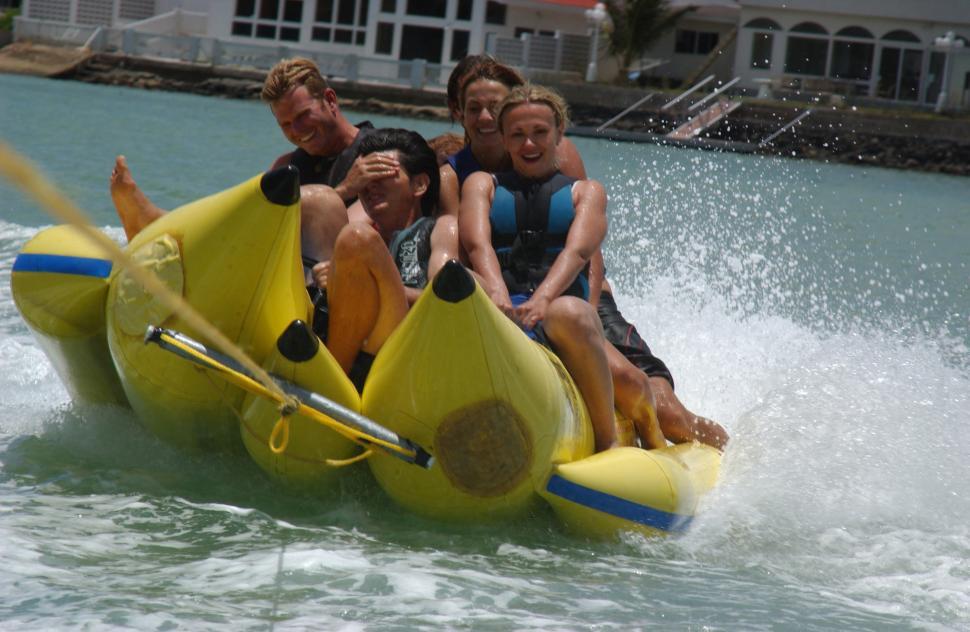 Free Image of Group of People Riding a Banana Boat in the Water 