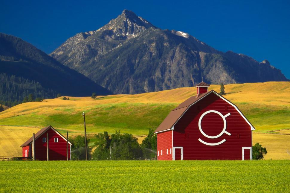 Free Image of Red Barn in Green Field With Mountains 