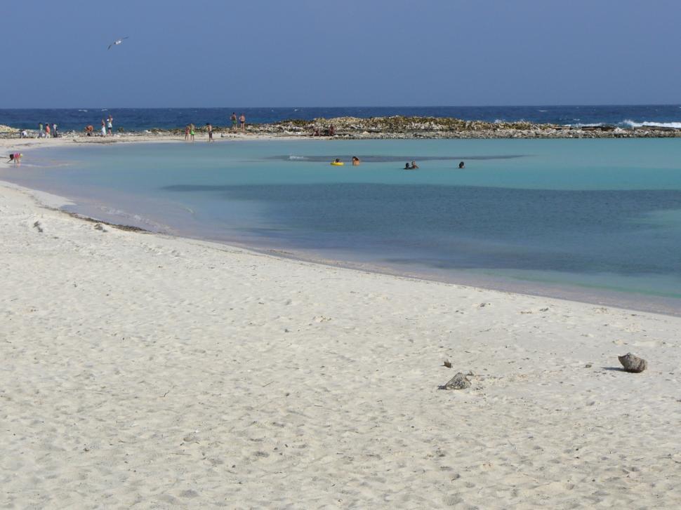 Free Image of People Enjoying Sandy Beach With Clear Blue Water 