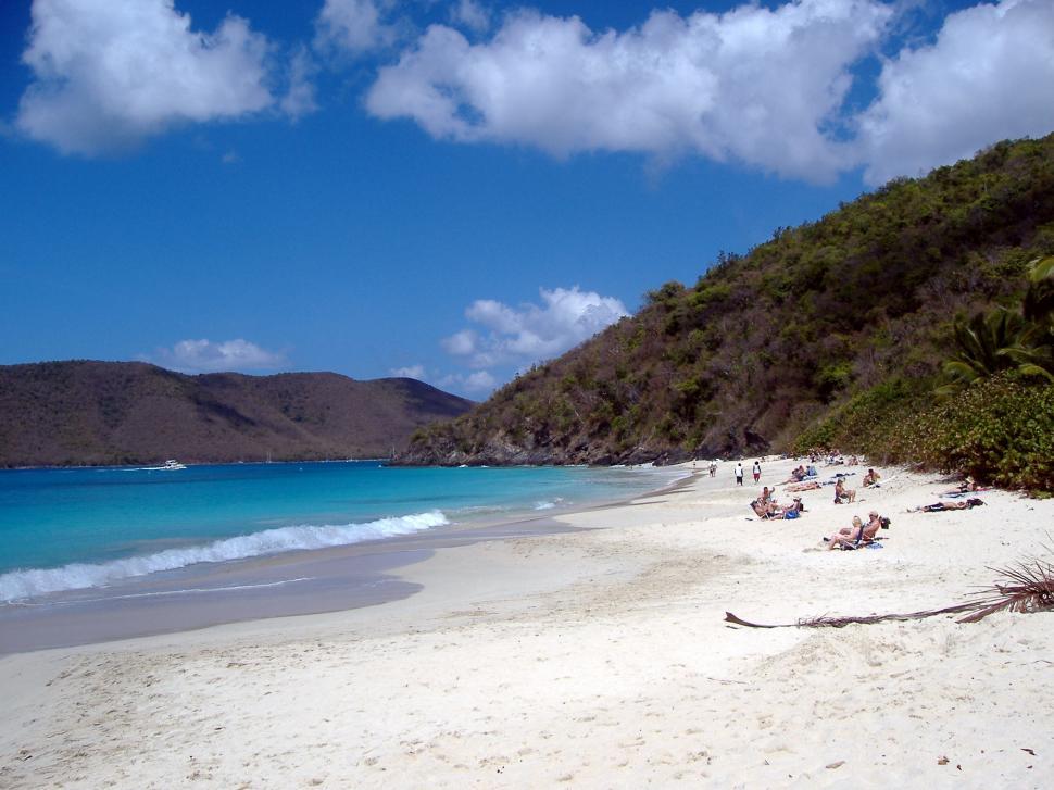 Free Image of White Sandy Beach With Blue Water and Mountains 