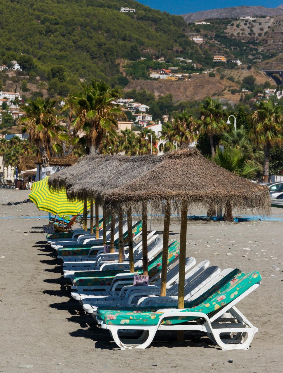 Free Image of Row of Lawn Chairs on Sandy Beach 