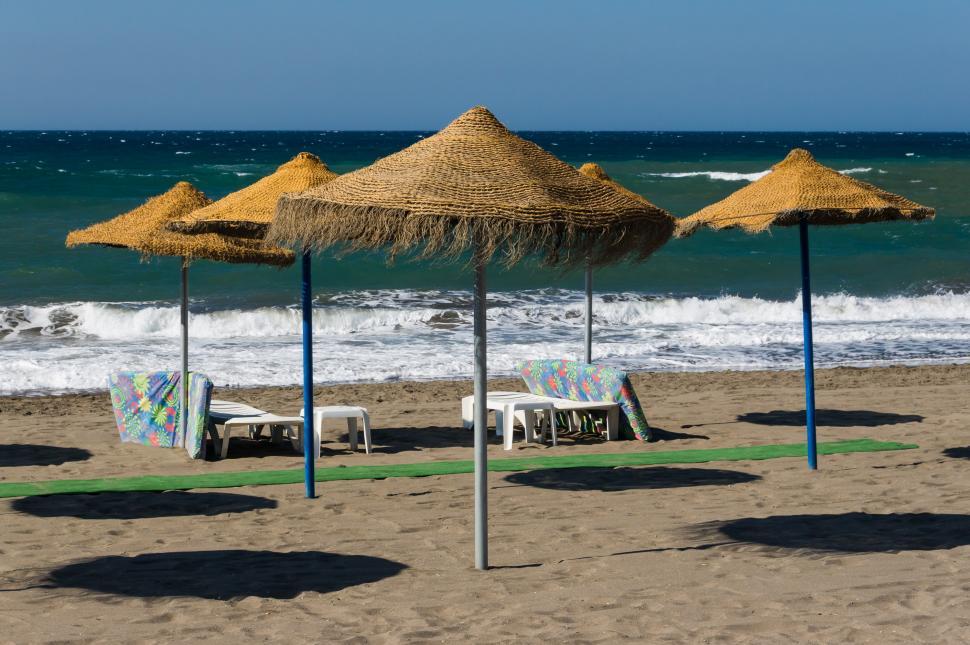 Free Image of Straw Umbrellas and Chairs on Beach 