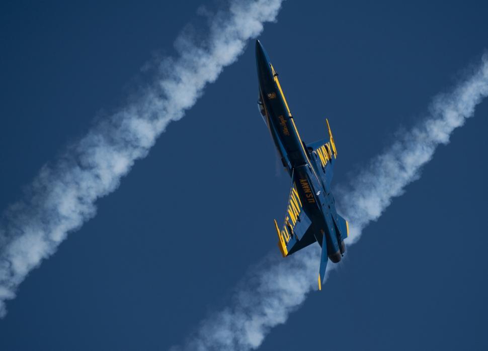 Free Image of Blue and Yellow Jet Flying Through Blue Sky 