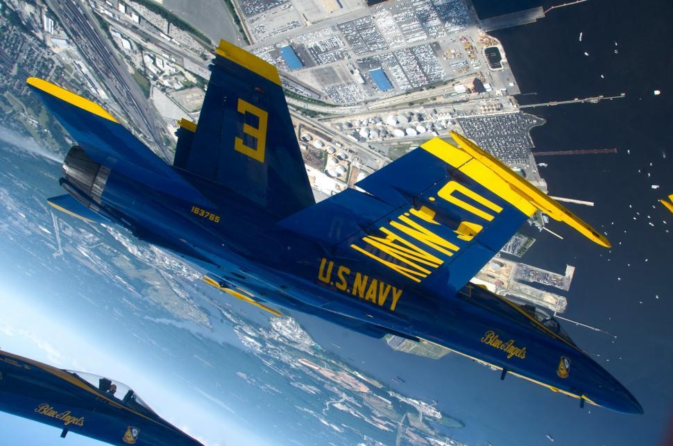 Free Image of Two Blue and Yellow Fighter Jets Flying Over the Earth 