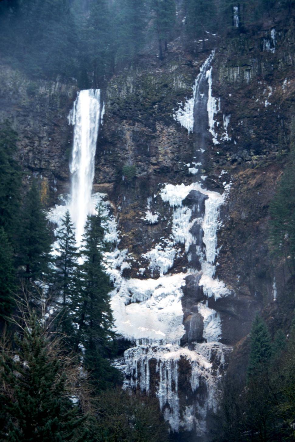 Free Image of Majestic Waterfall Surrounded by Snowy Trees 