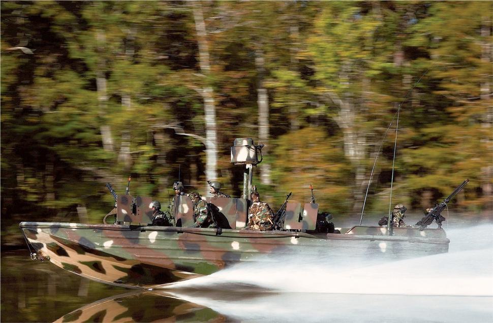 Free Image of Boat Speeding Through Water With Trees in Background 