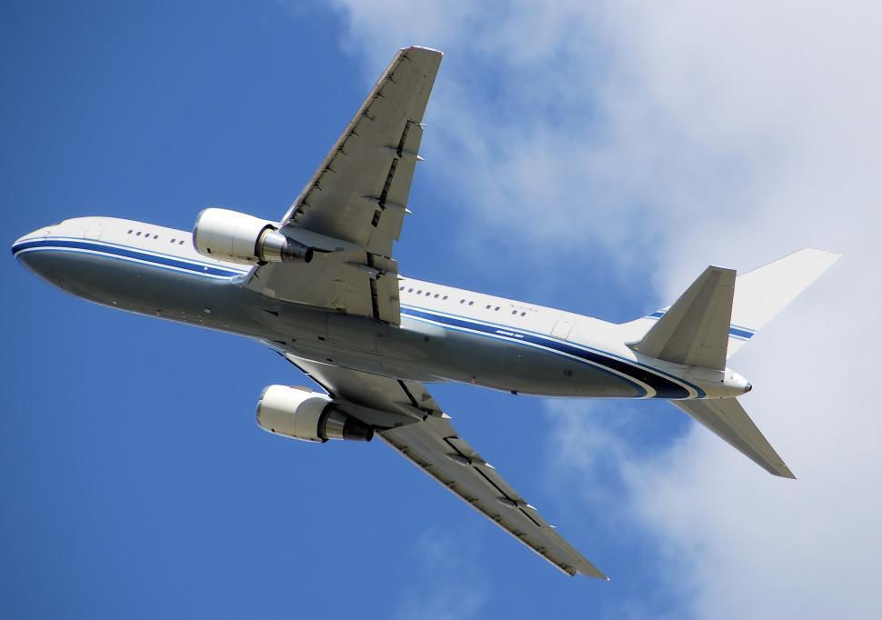 Free Image of Large Jetliner Flying Through a Blue Cloudy Sky 