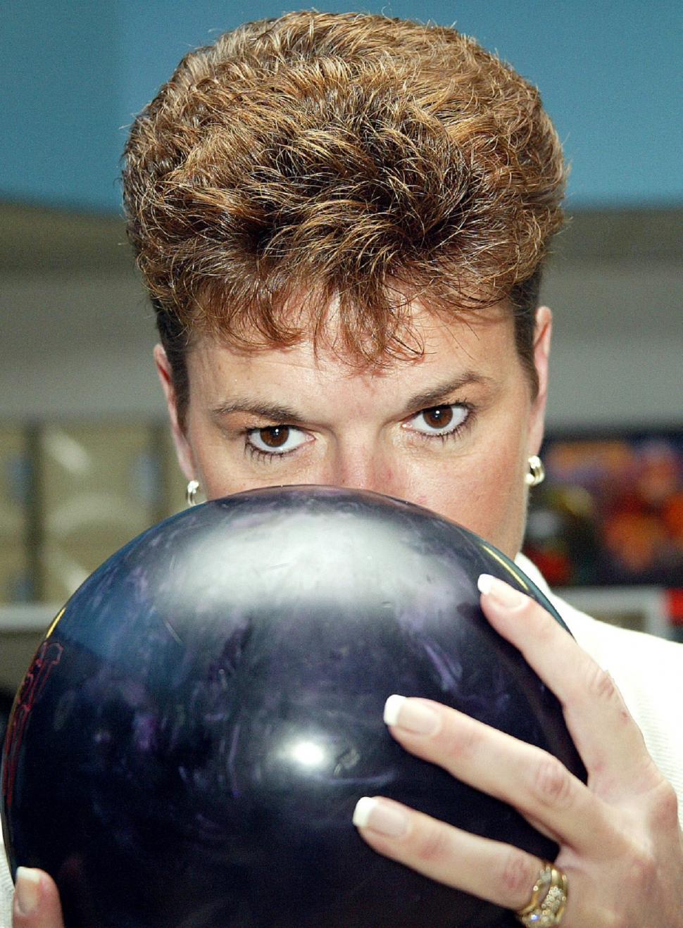 Free Image of Woman Holding Bowling Ball to Face 