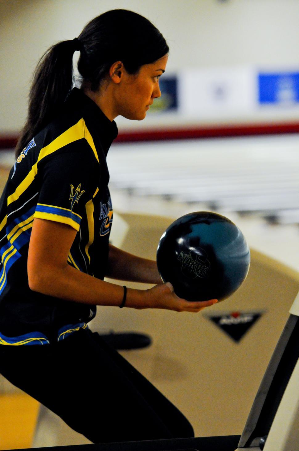 Free Image of Woman Holding Bowling Ball and Bowling Rack 