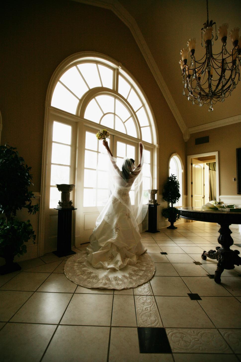 Free Image of Woman in Wedding Dress Standing in Room 