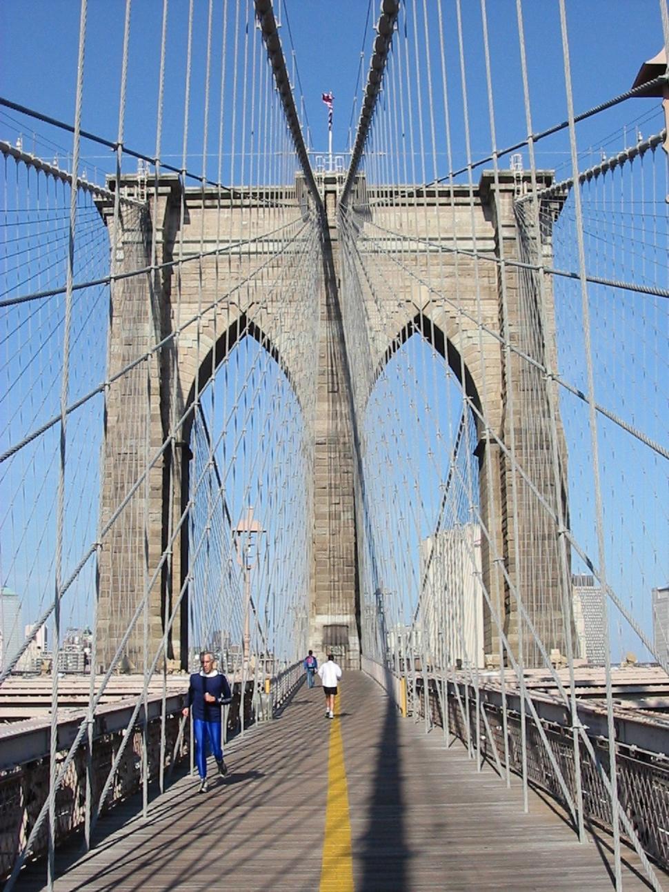 Free Image of Person Walking Across Bridge With Blue Sky Background 
