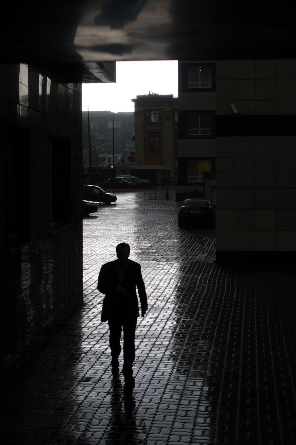 Free Image of Man Walking Down a Rainy Street 