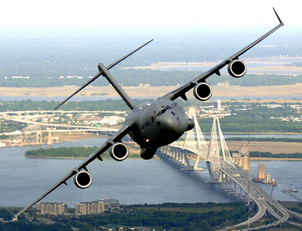 Free Image of Large Airplane Flying Over Bridge 