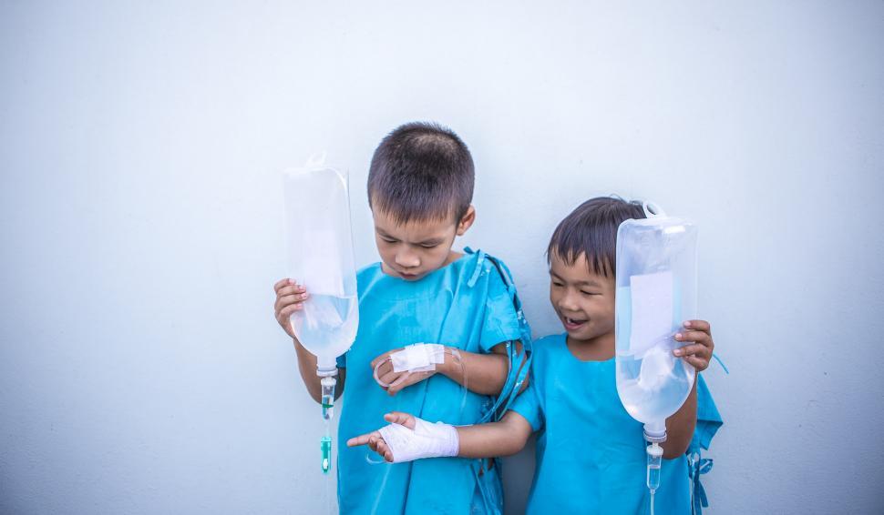 Free Image of Two Young Boys in Blue Shirts Holding Plastic Tubes 