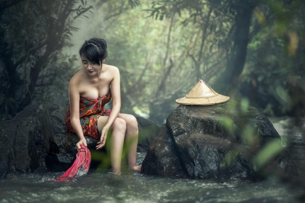 Free Image of Woman in Red Dress Sitting on Rock 