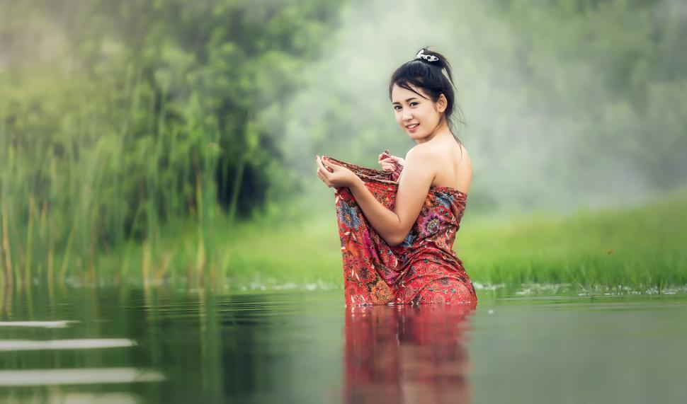 Free Image of Woman in Red Dress Sitting in Water 