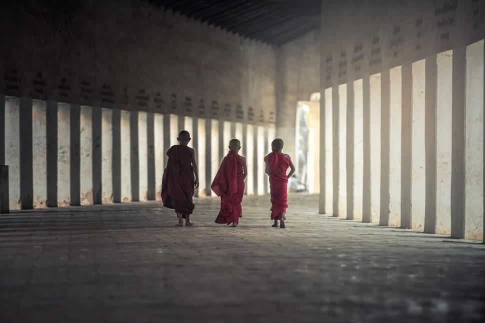 Free Image of Two Women in Red Robes Walking Down a Hallway 