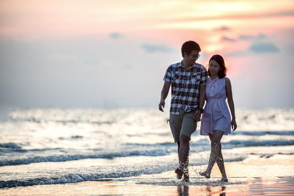 Free Image of A Man and a Woman Walking on the Beach 