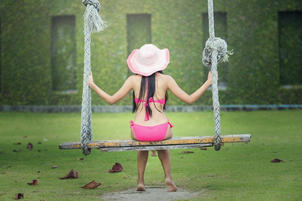 Free Image of Woman in Pink Bikini Sitting on Swing 