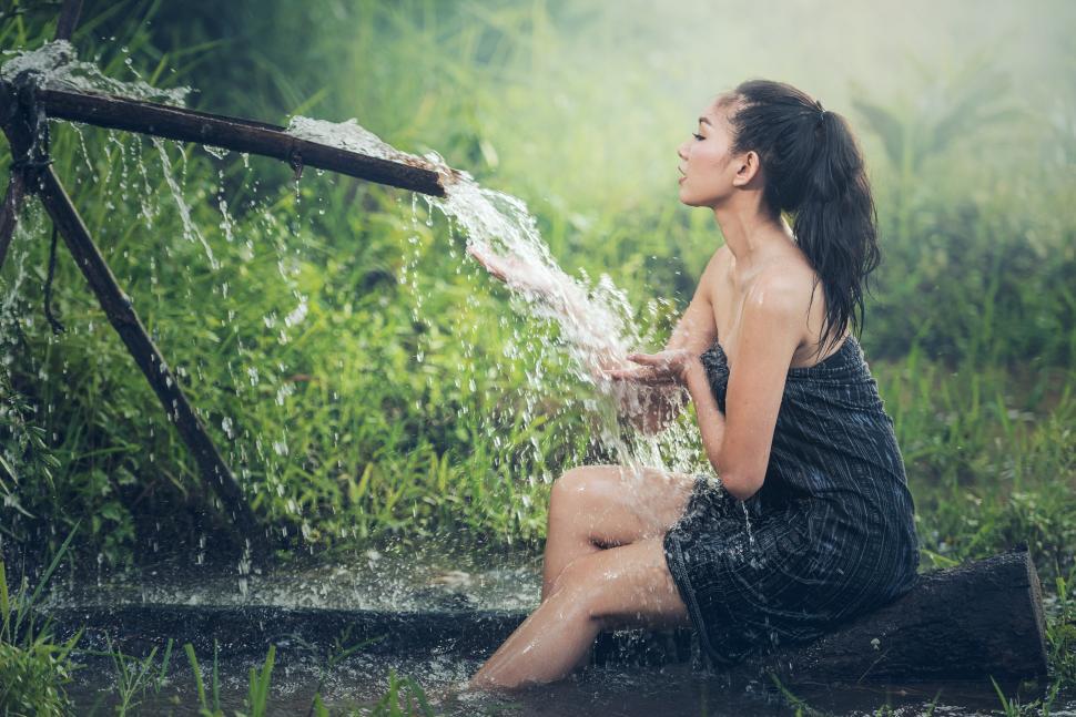 Free Image of Woman in Black Dress Sitting in Water 