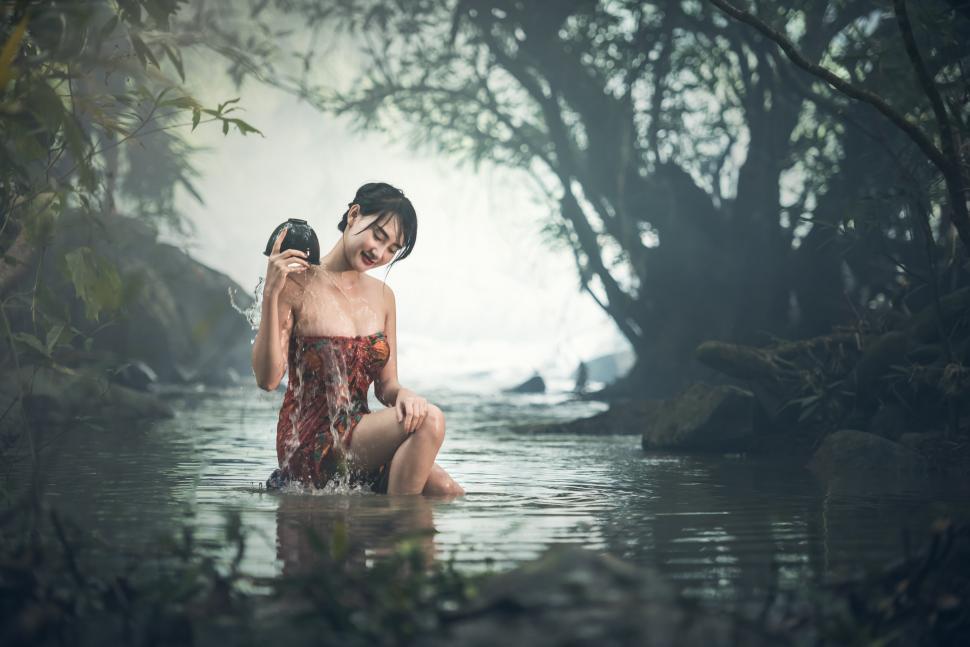 Free Image of Woman in Body of Water Holding Camera 