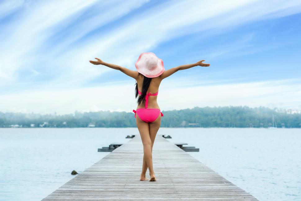 Free Image of Woman in a Pink Bikini Standing on a Dock 