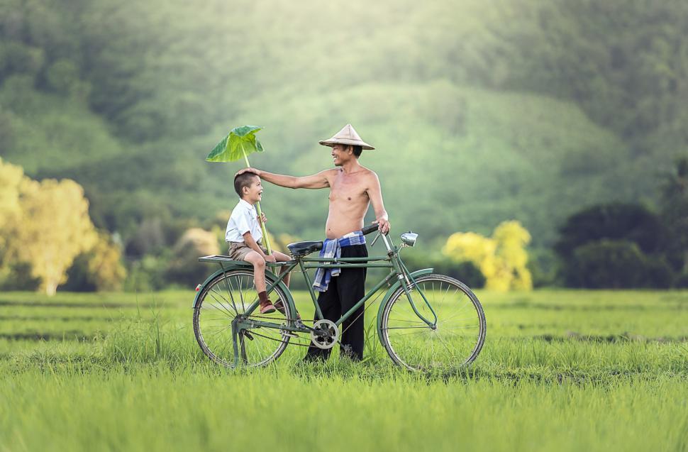 Free Image of Man and Boy Riding Bike in Field 