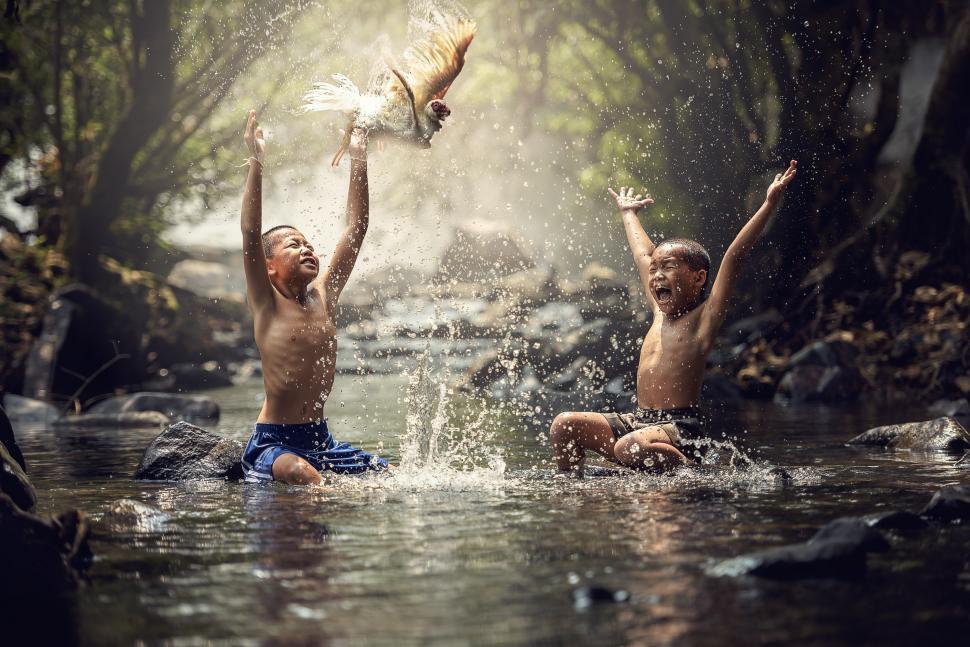 Free Image of Two Young Boys Playing in a Stream of Water 