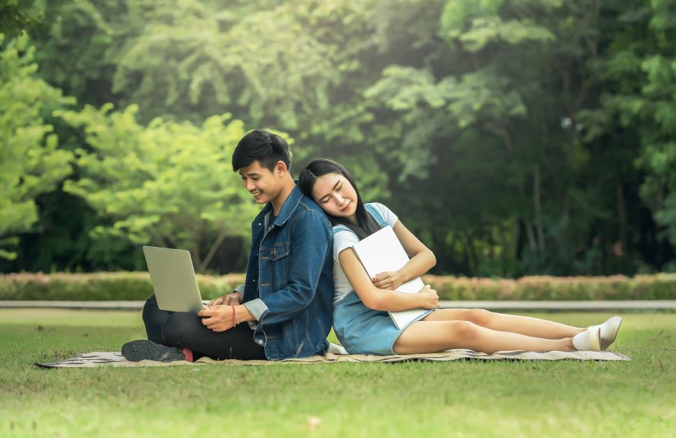 Free Image of Man and Woman Sitting on a Blanket on the Grass 