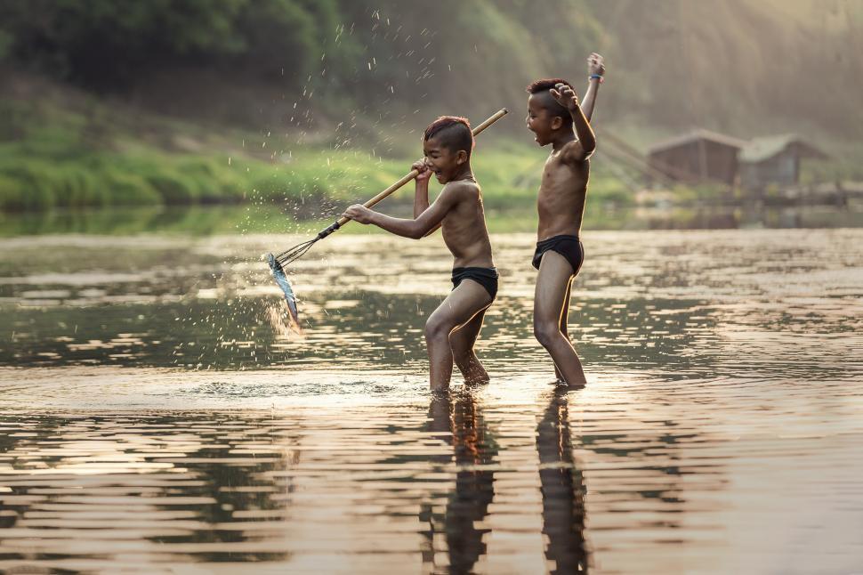 Free Image of Kids Standing on Top of Body of Water 