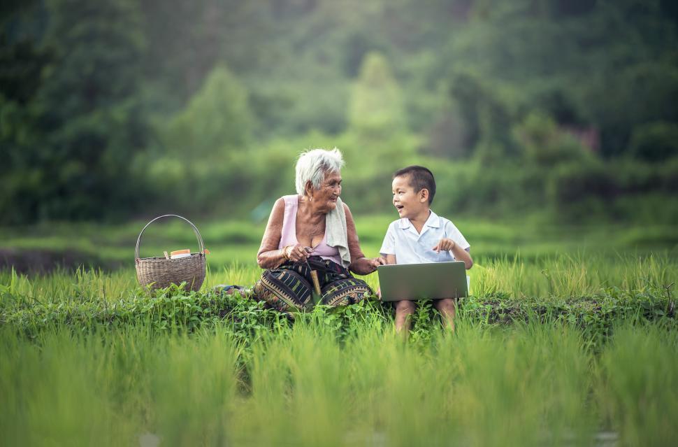 Free Image of Older Woman and Young Boy Sitting in a Field 