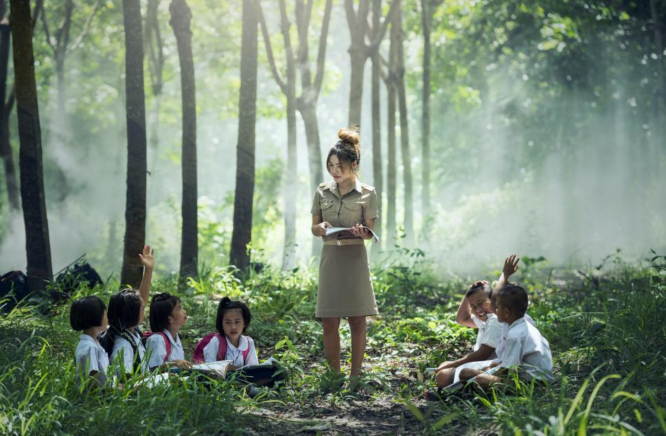 Free Image of Woman Standing in Forest Surrounded by Children 