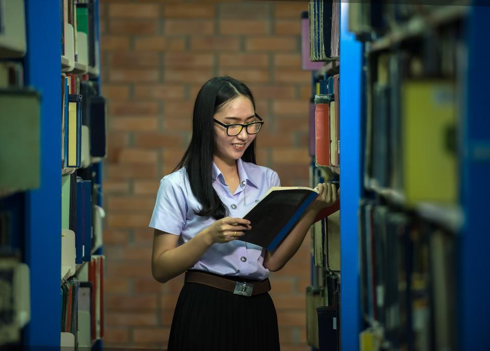 Free Image of Woman Reading Book in Library 