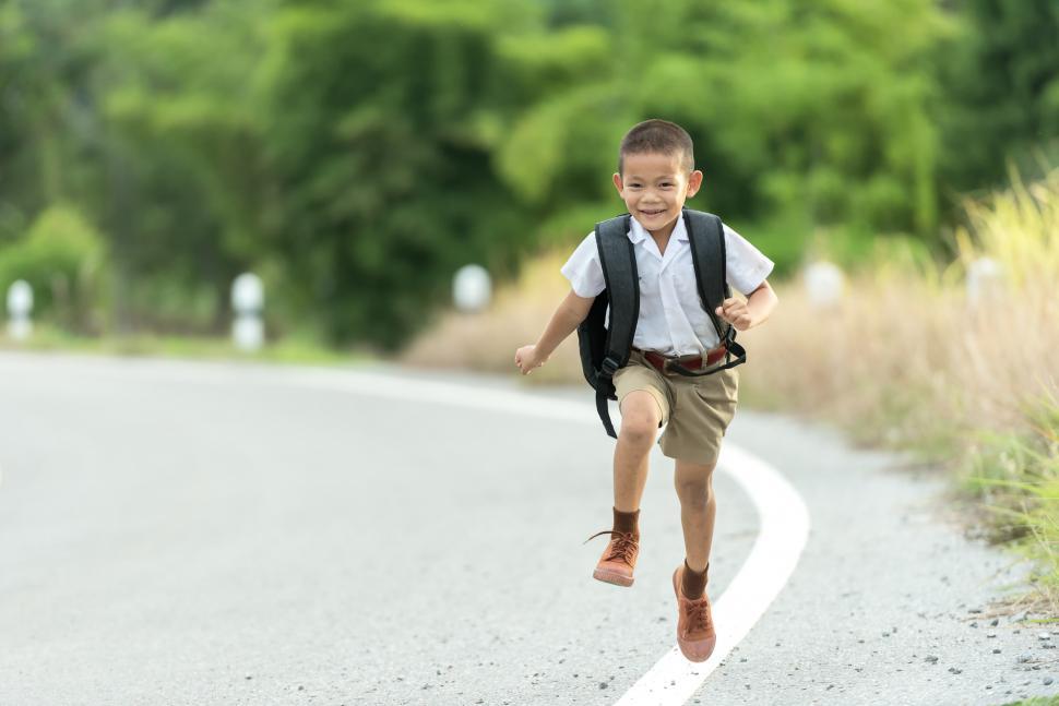 Free Image of Young Boy Running Down the Road 