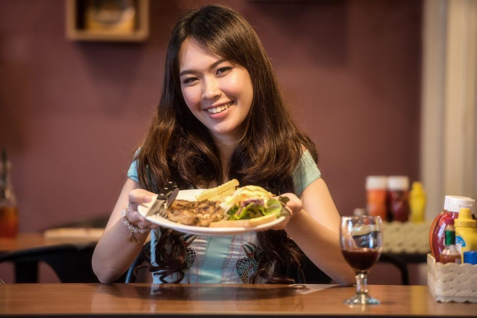 Free Image of Woman Sitting at Table With Plate of Food 