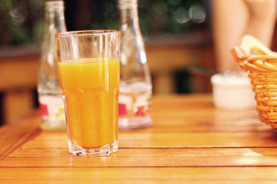 Free Image of Glass of Orange Juice on Wooden Table 