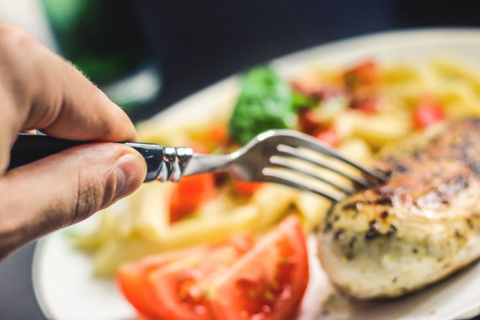 Free Image of Person Holding Fork Over Plate of Food 