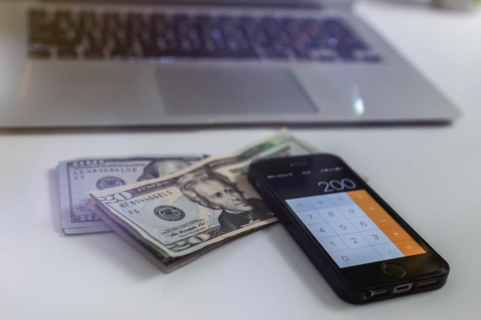 Free Image of Cell Phone on Top of a Pile of Money 