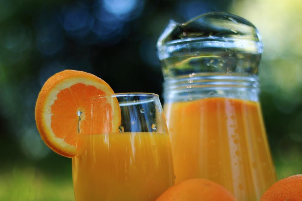 Free Image of Glass of Orange Juice Next to Bottle of Orange Juice 