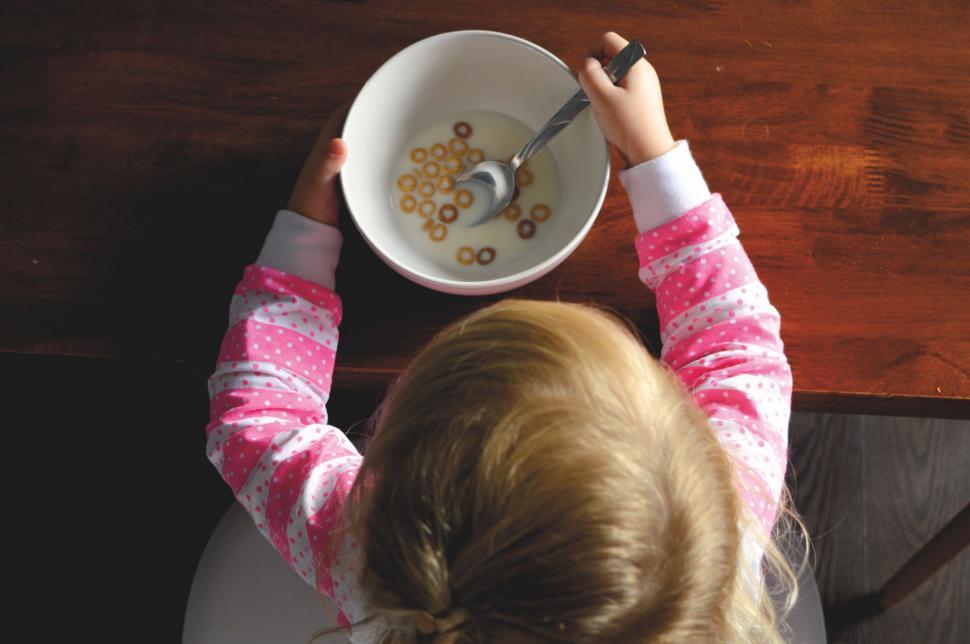Free Image of Little Girl Eating Cereal at Table 