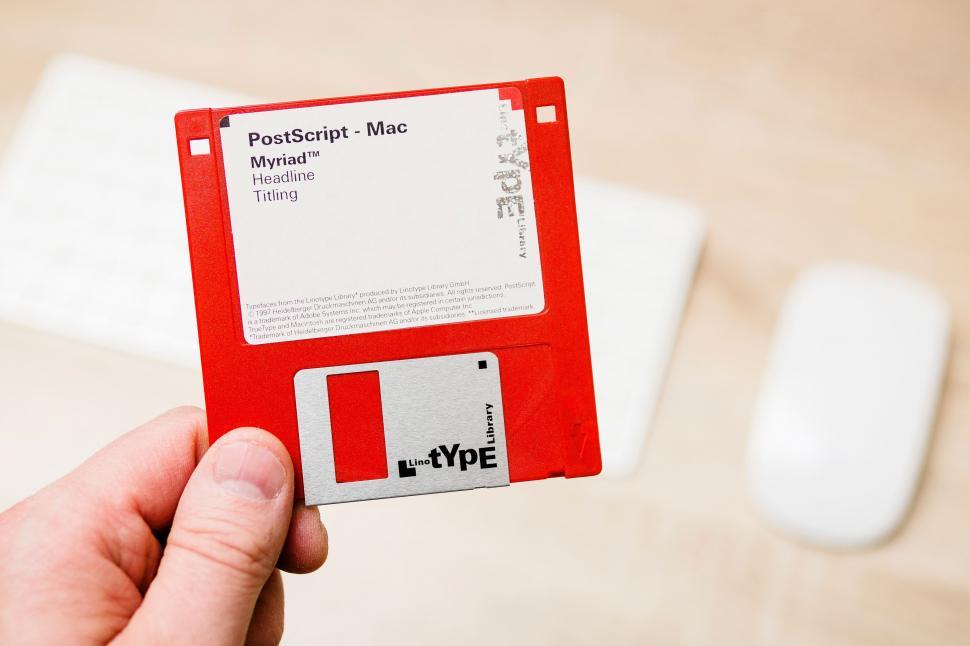 Free Image of Hand Holding Red and White Floppy Disk 