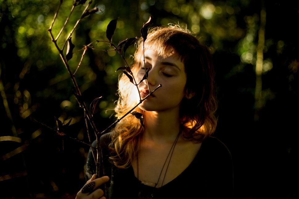 Free Image of Woman Standing in a Forest With Eyes Closed 
