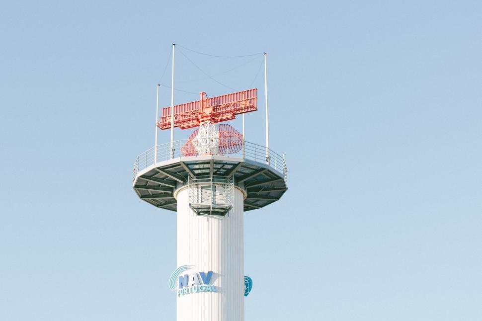 Free Image of Tall White Tower With Red Sign 