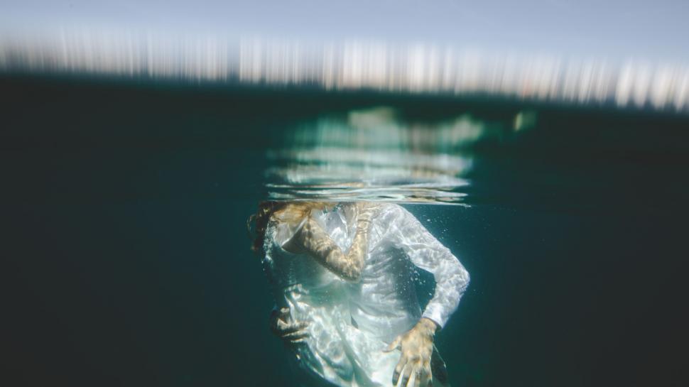 Free Image of Person Floating in Water Wearing Plastic Bag 