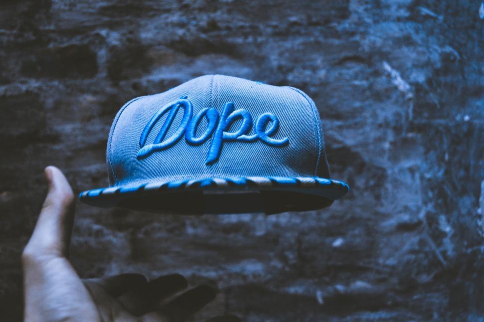 Free Image of Hand Holding Blue Dope Hat 